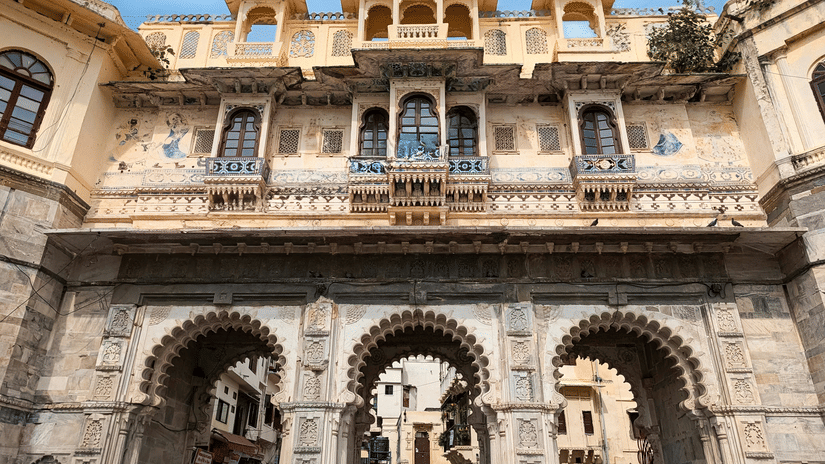 Ornate stone gateway with traditional Rajput architecture and intricate carvings at Ambrai Ghat, Udaipur.