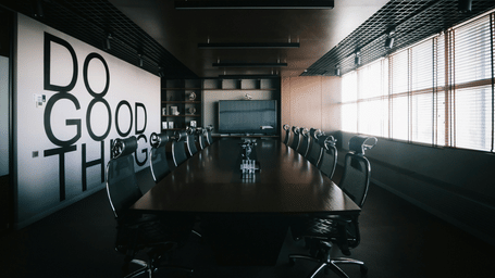 A stylish boardroom with a text displayed on the wall.