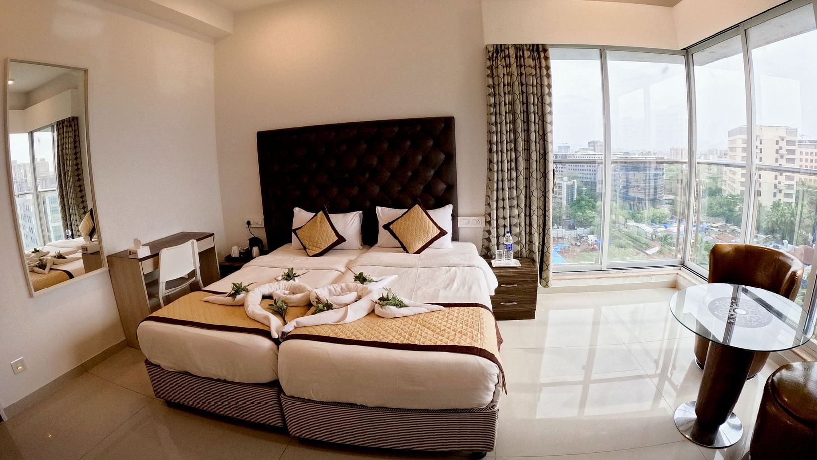 A picture of two beds in a room with glass windows