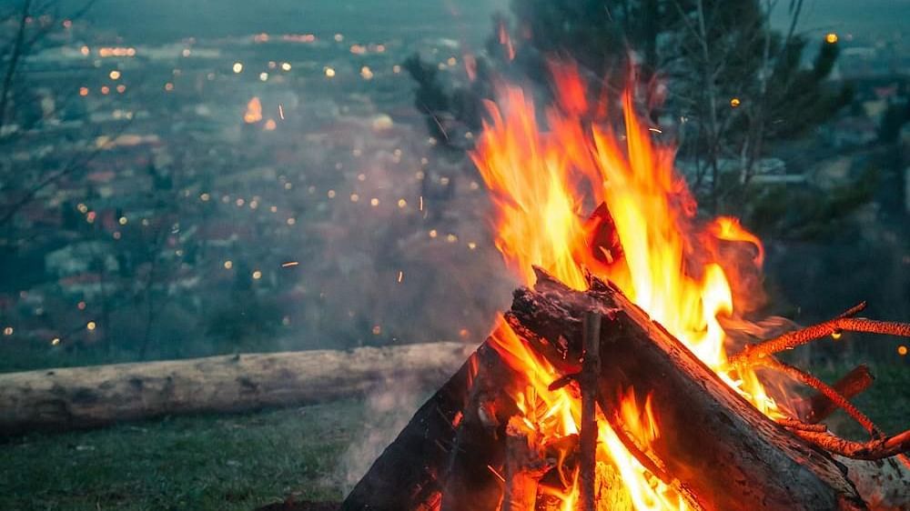Image of a bonfire with a city in the background | Faraway Cottages, Auli