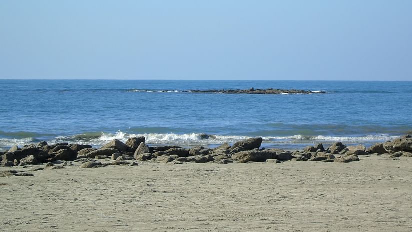 An image of a sandy beach nestled by crystal clear sea water