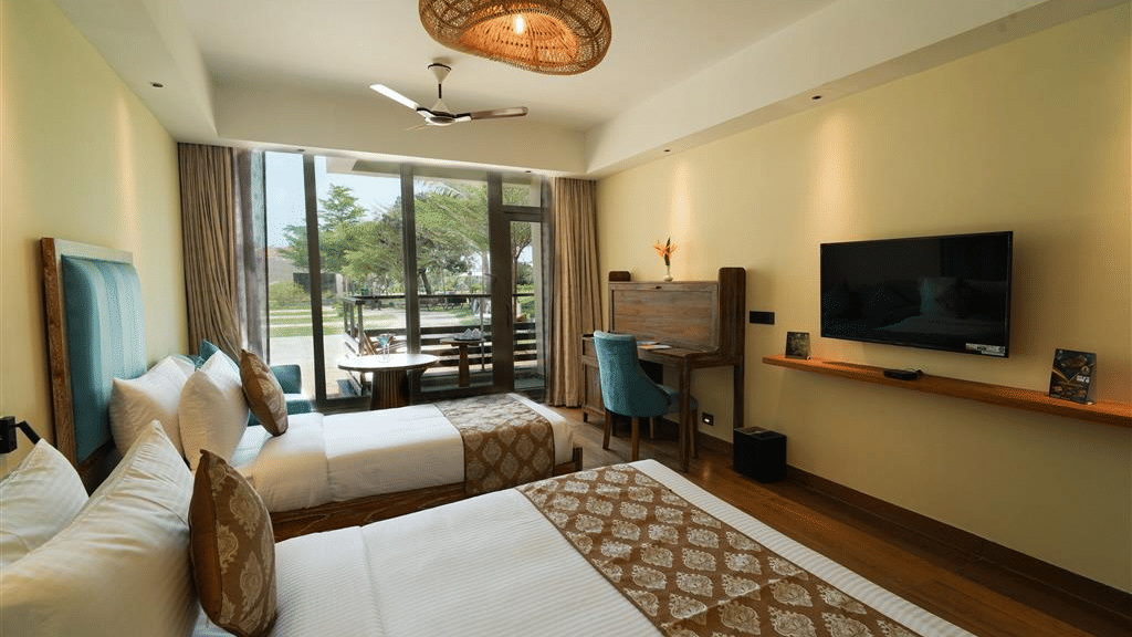 The Jr. Family Suite - Abode Executive Lounge Access at MGM Dizzee World featuring 2 well-made beds, a flat-screen television, wooden flooring and large windows with a view outside.