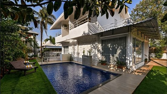 A breathtaking view of a Maxxvalue Klub Klass Villa, Lonavala featuring a stunning infinity pool, lush gardens, and modern architectural design.