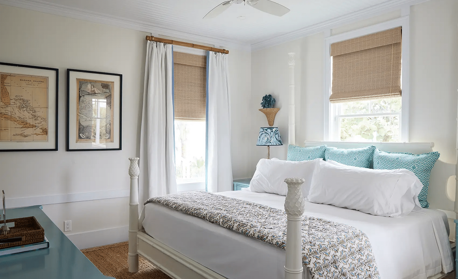 Bright bedroom with a four-poster bed, framed art, and a ceiling fan | Abaco Inn
