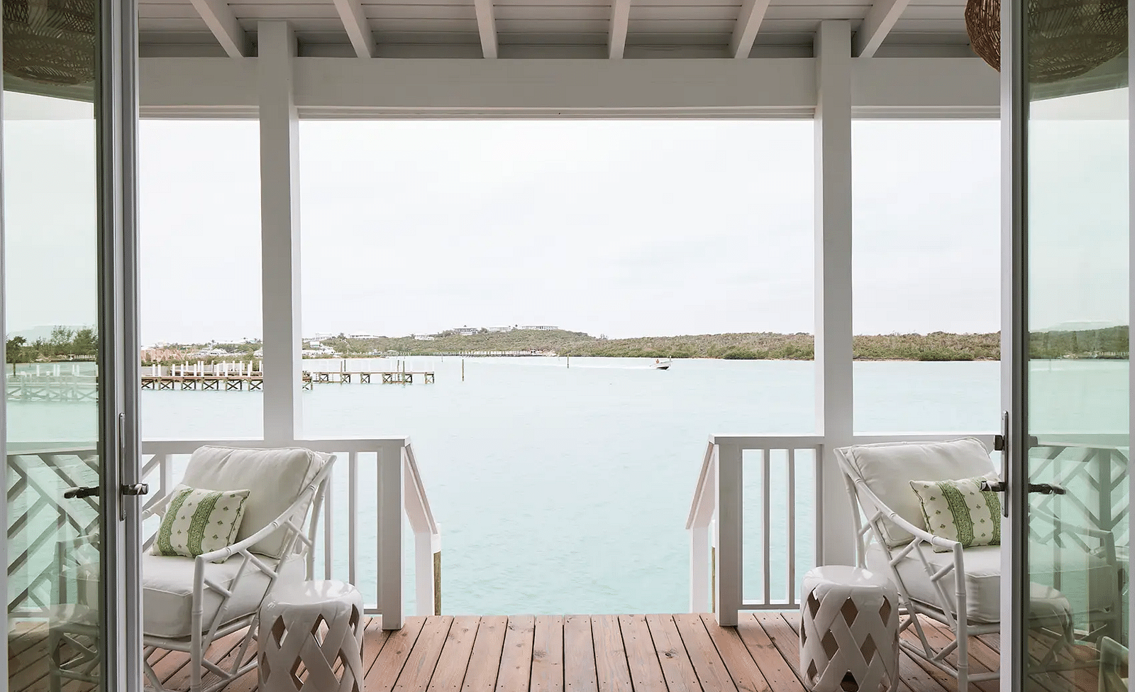 Waterfront balcony with white chairs overlooking the ocean | Abaco Inn