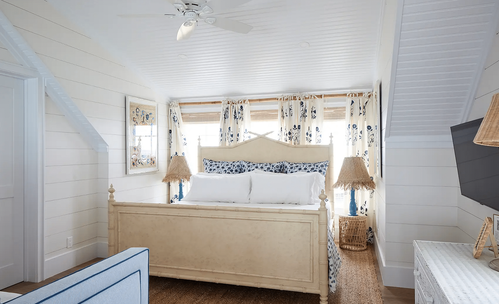 Bedroom with a wooden bed frame, neutral bedding, and framed artwork | Abaco Inn
