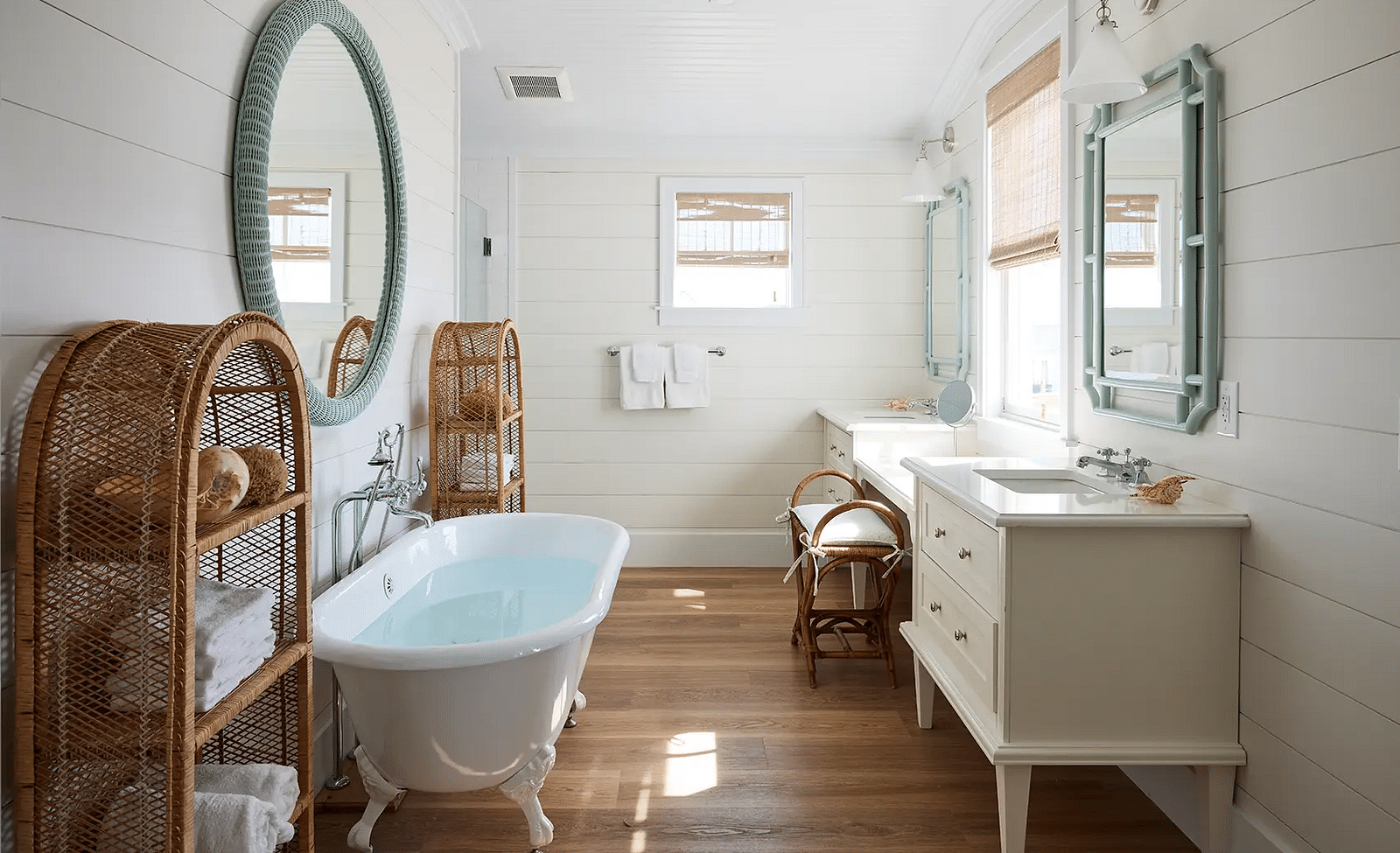 Bathroom with a freestanding bathtub, vanity, and a round mirror | Abaco Inn