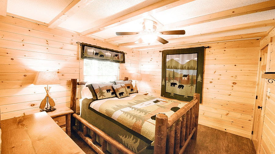 corner view of a bedroom with a double bed along with a brightly lit lamp kept on the bed side tablev