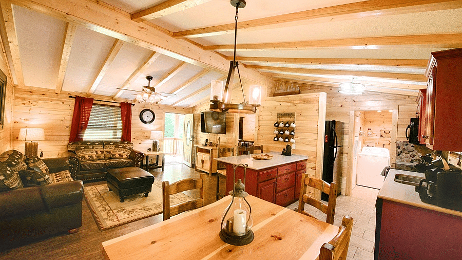 corner view image of the dining area also featuring the kitchen and the common seating area with a wooden ceiling - Historic Tapoco Lodge