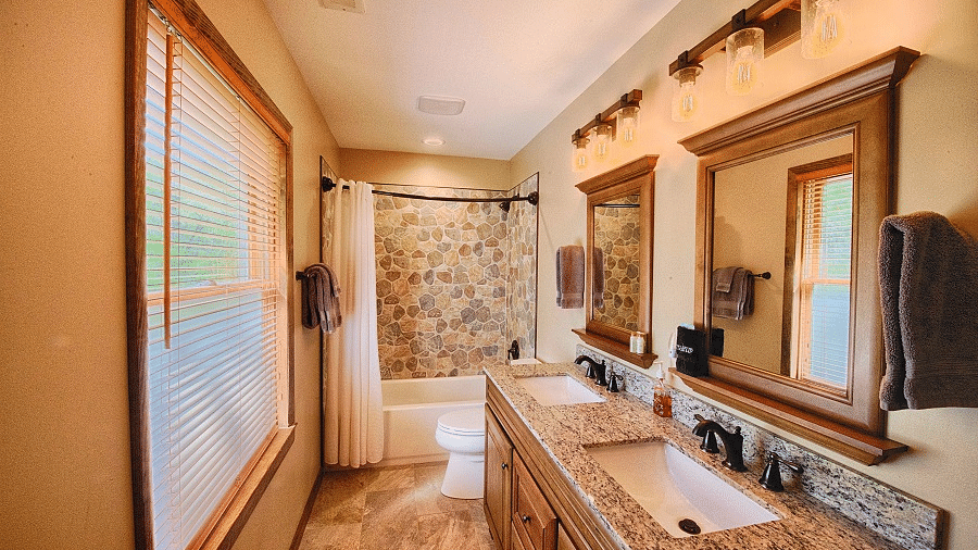 a bathroom with a large window opposite the two wash basins and a bath tub in the far end - Historic Tapoco Lodge