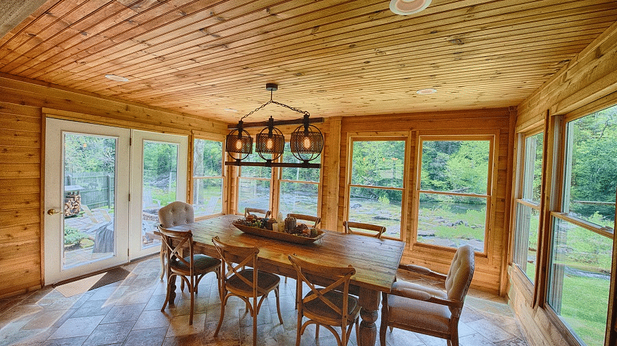 a beautiful dining area surrounded by huge glass windows with views of the lush green surroundings - Historic Tapoco Lodge