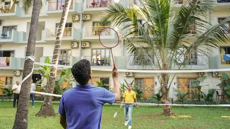 People playing badminton on a grassfield at Indie Stays Resort, Goa.