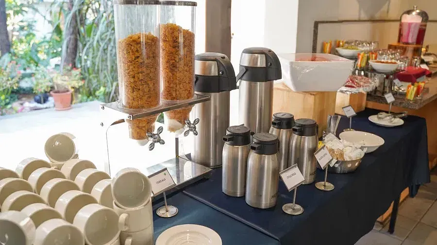 Buffet counter with assorted food items and drinks placed in Aqua Vida Restaurant at Indie Stays Resort, Goa.