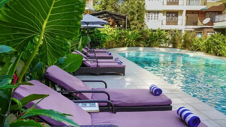 Lawn chairs near the swimming pool area at Indie Stays Resort, Goa.