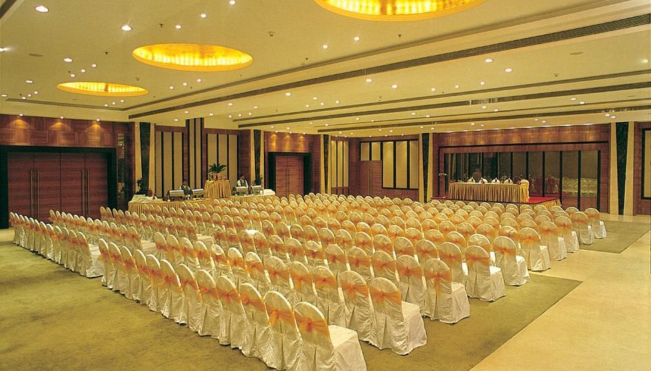 An event hall with chairs placed facing the podium at Nirvana Luxury Hotel, Ludhiana.