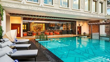 Outdoor pool area with seating and views of the hotel facade.