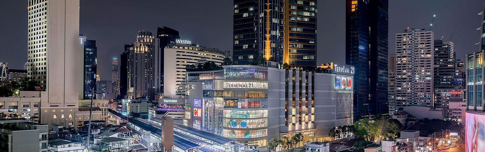 Wide angle view of Asok at night with high rise building and night sky in the background