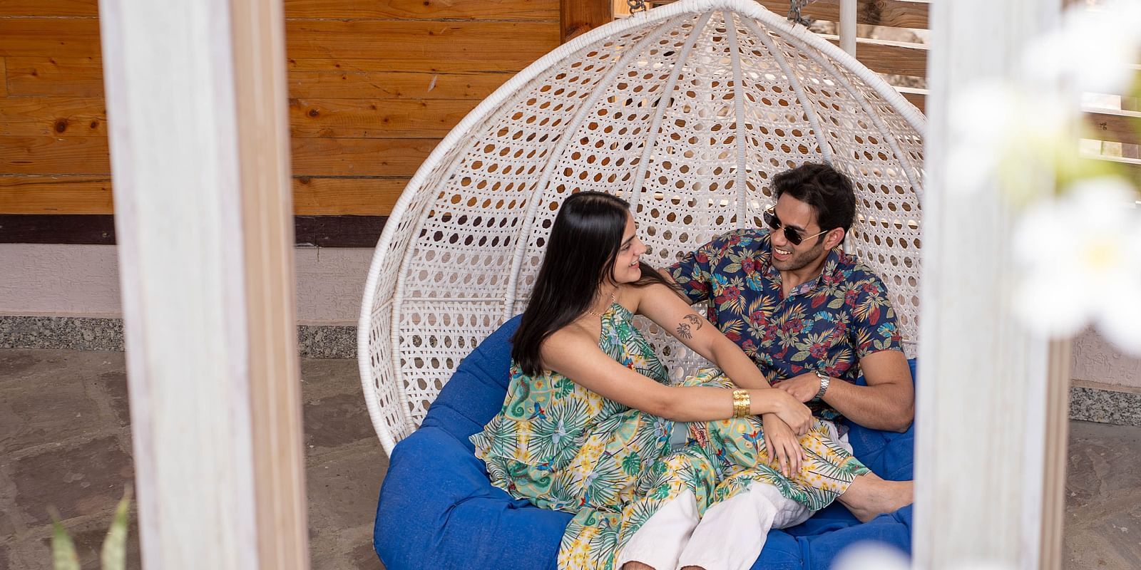 Two people sitting in a hanging chair or swing.