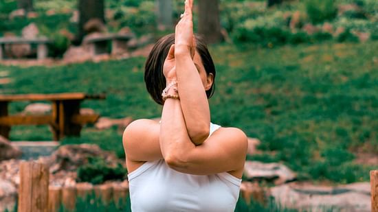 a woman doing yoga amidst lush green surrounding