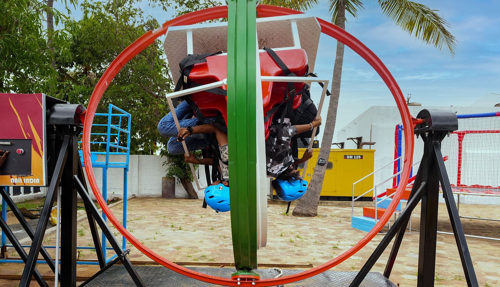 A gyro ride where people are sitting upside upside down in MGM Dizzee World. The ride consist of a round ring attached with seats which makes them spin and rotate in all directions. 
