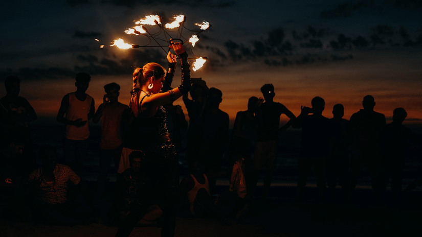 a woman performing fire dance in front of a crowd