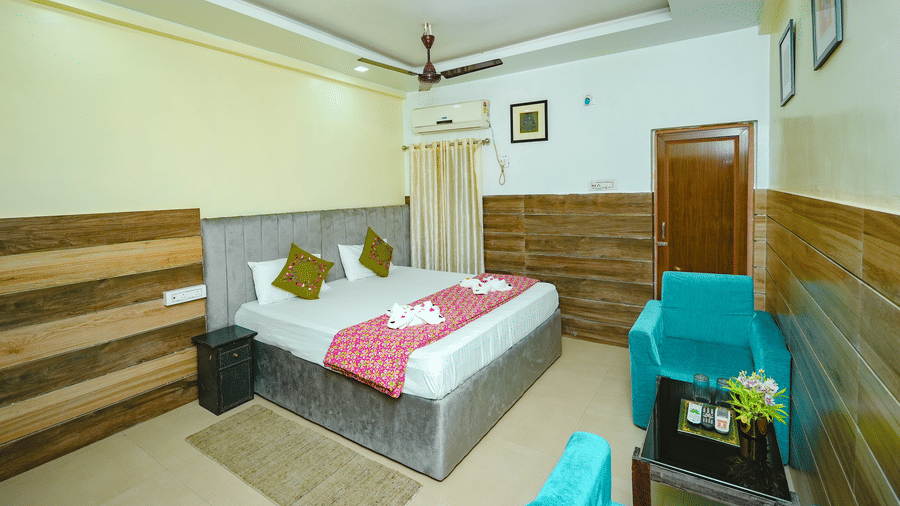 The Standard Double Bed Room featuring a bed, a seating area with sofa and centre table, and a bedside table at Rangamati Garden Resort