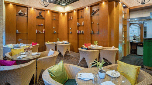 Restaurant setup with food counters and seating at Golden Tulip, Udaipur.