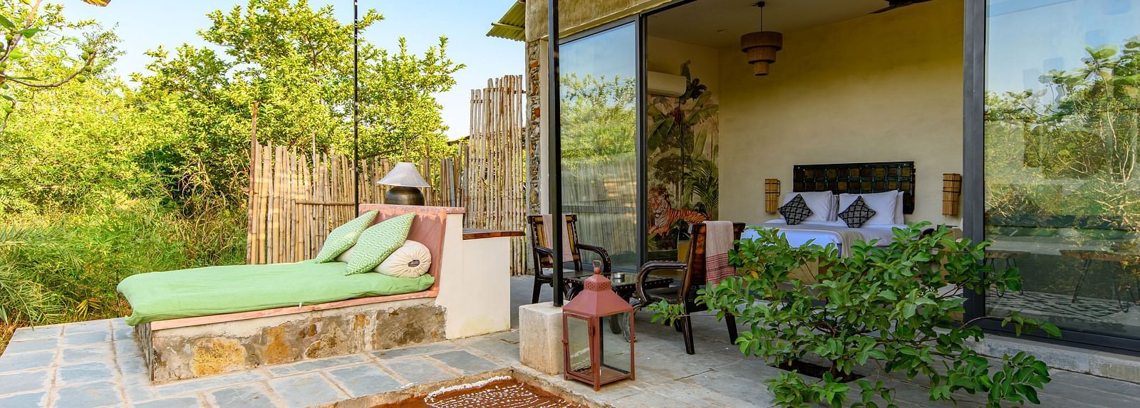 An image of a room with outdoor seating amidst lush greenery - Utsav Camp Sariska