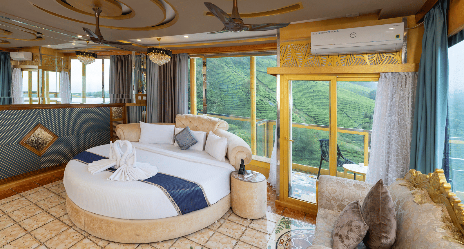 The bedroom of Jacuzzi 180-degree Suite at Parakkat Nature Hotel and Resorts, Munnar, featuring a round bed, decorative ceiling work, air conditioning, and full-length windows with an expansive landscape view.