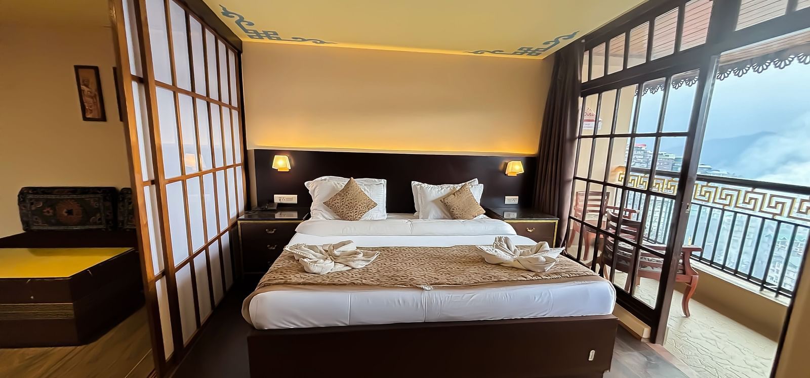 Bedroom with a balcony offering mountain views at Avianna Hungry Jack, Gangtok.