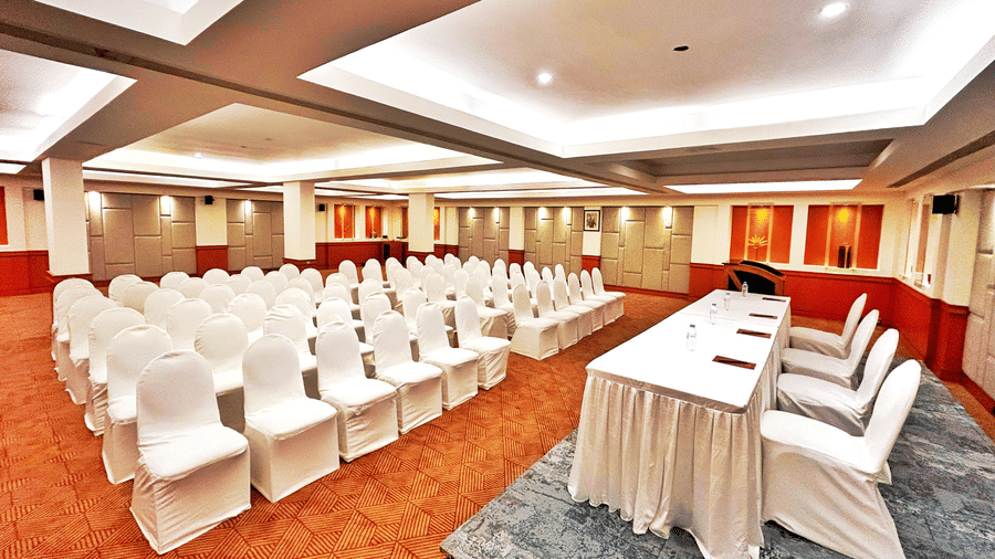 Banquet hall set up in theatre-style seating with white chairs and a head table at The Residency Karur, ideal for conferences and formal gatherings