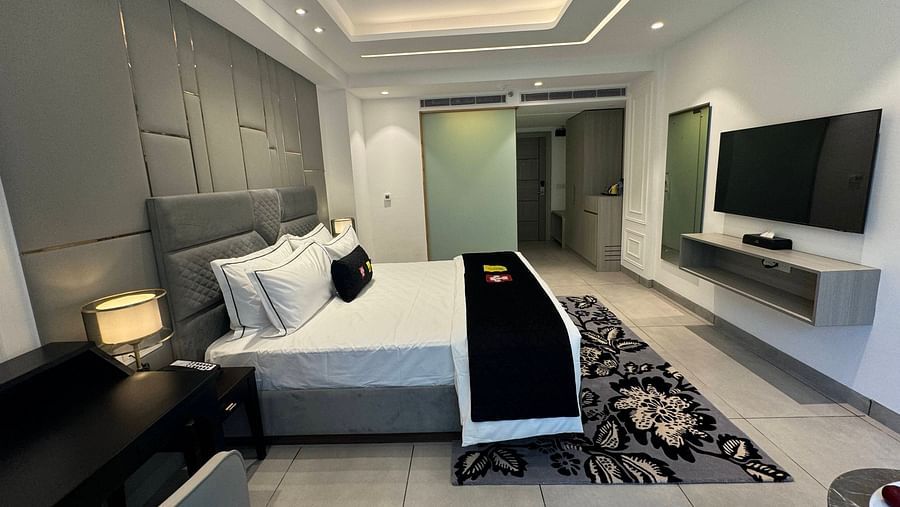 an image of a deluxe room with a television and a wardrobe at Mastiff Select Mandavya Dharamkot, McLeodganj