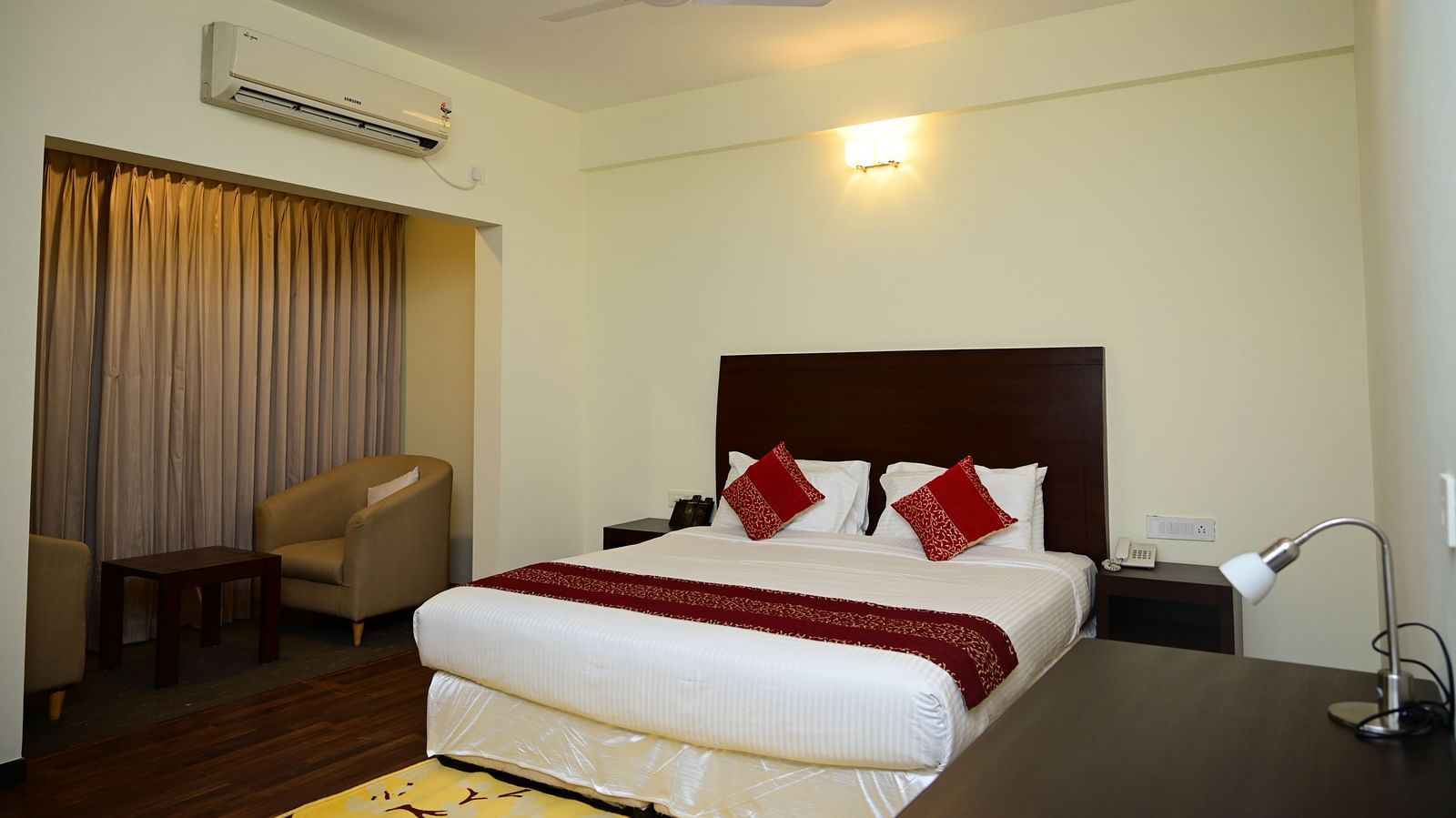 A double bed with red blanket and red pillow covers in the Executive Suite at Sterling Keys by TGI 4