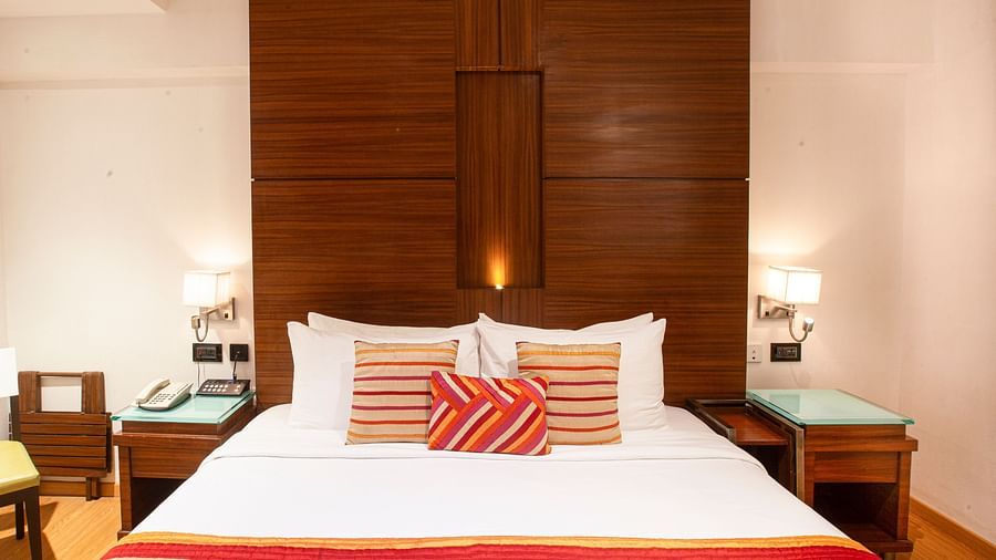 A front view of the Executive room with comfy bed and bedlight beside the bed..