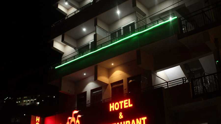 Facade of Hotel Panchvati Inn with cars parked outside 2