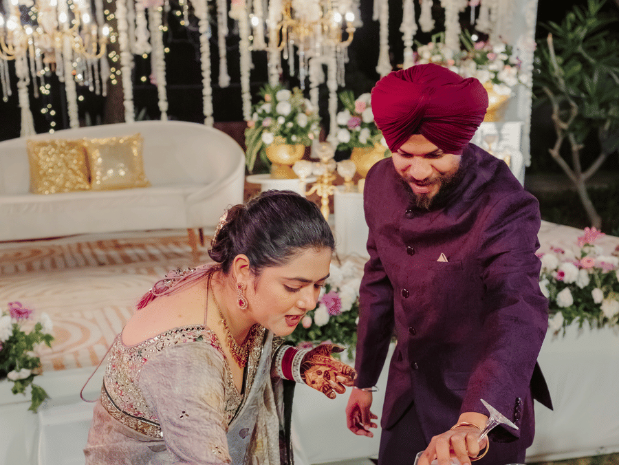 Jaswinder and Ritika cutting wedding cake at Umaid Palace reception.