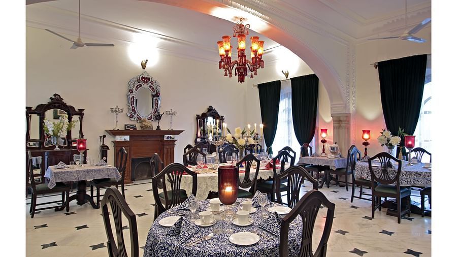 A lavish indoor dining area with classic interiors, chandeliers, and ornate furniture - Khas Bagh, Jaipur.