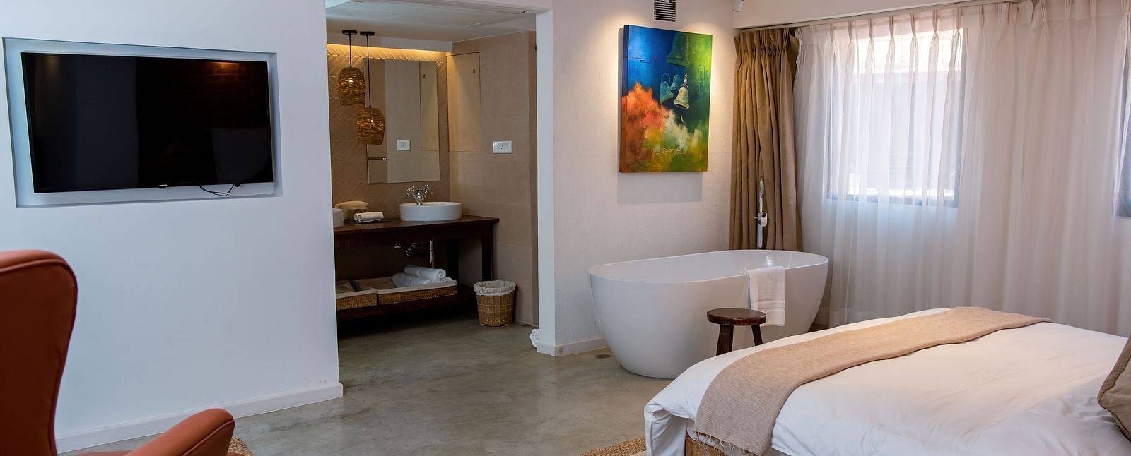 The Nepali Suite featuring a bed, flat screen TV, a sofa and a bathtub - The Nanee