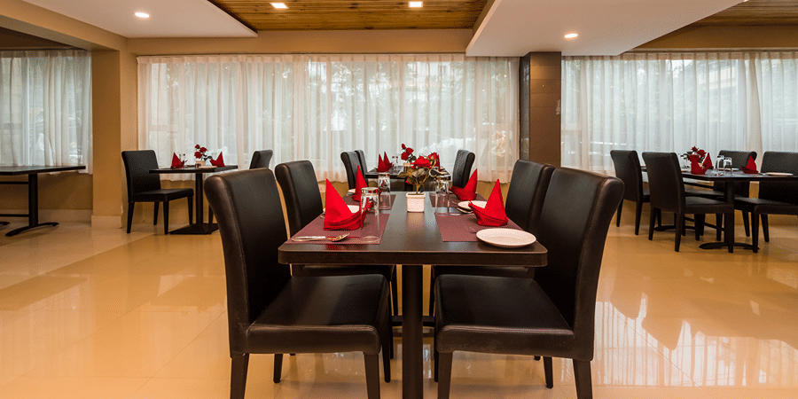 Wild Orchid restaurant at Central Courtyard Boutique Hotel, Siliguri, featuring seating arrangement under warm lighting