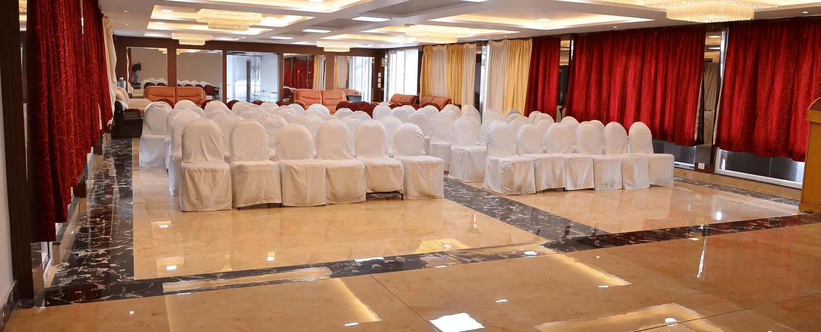 A banquet hall with bright lights and organised seating, perfect for conferences and celebrations - Benzz Park, Kodaikanal