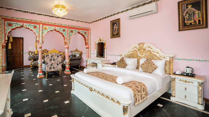 The large plush bed and beautifully decorated pillars of the Maharaja Bedroom - Stone Wood Riverfront Resort, Siolim
