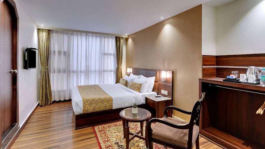 A double bed and an armchair in the Premium Room at Hotel Sumitel Vista T.V Tower 