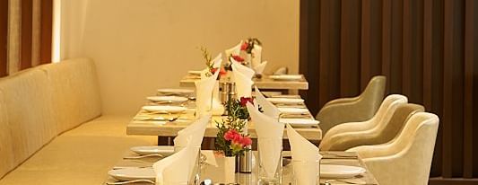 Duplicate of a linear seating arrangement with a warm lighting and lights dropped from the ceilings at The Hamuse Hotel, Kodaikanal.