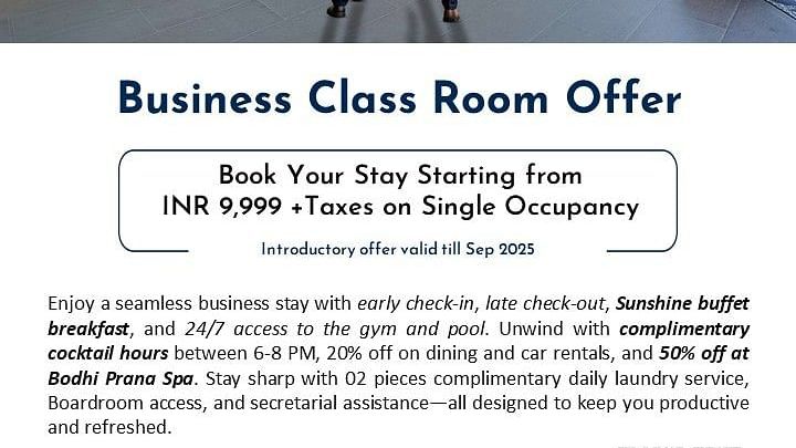 Creative corporate photography showing two businessmen in suits walking through the modern, spacious lobby of Radisson Bengaluru City Center Ulsoor Lake, featuring contemporary design elements and orange accent furniture, promoting the Business Class Room 