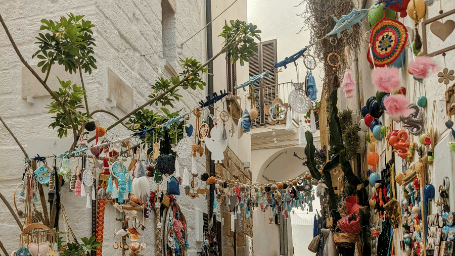 A narrow alley with walls, decorated with handmade crafts