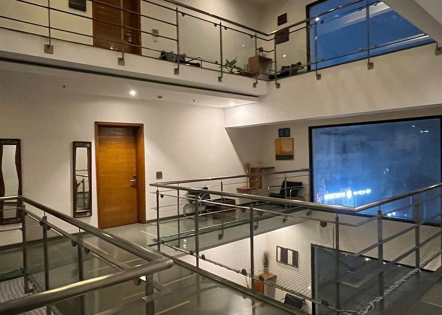 Interior view of a building with open levels, glass railings, and visible doorways - Astra Hotels and Suites Spice Garden