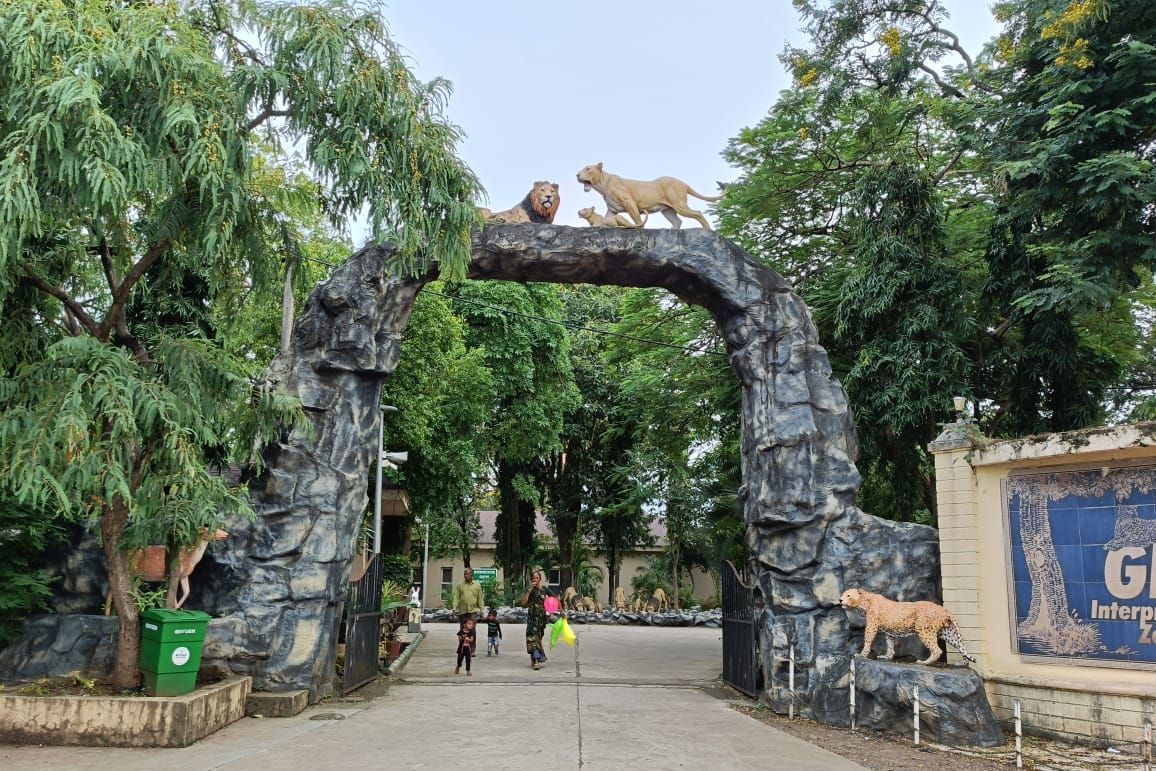 Entrance of Devaliya Park featuring a huge stone structure gate with lions amidst the green trees.
