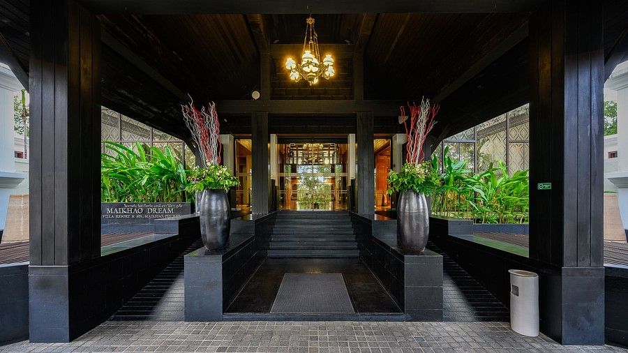 exterior image of the entrance featuring a glass door leading towards the lobby - Maikhao Dream Villa Resort & Spa, Phuket