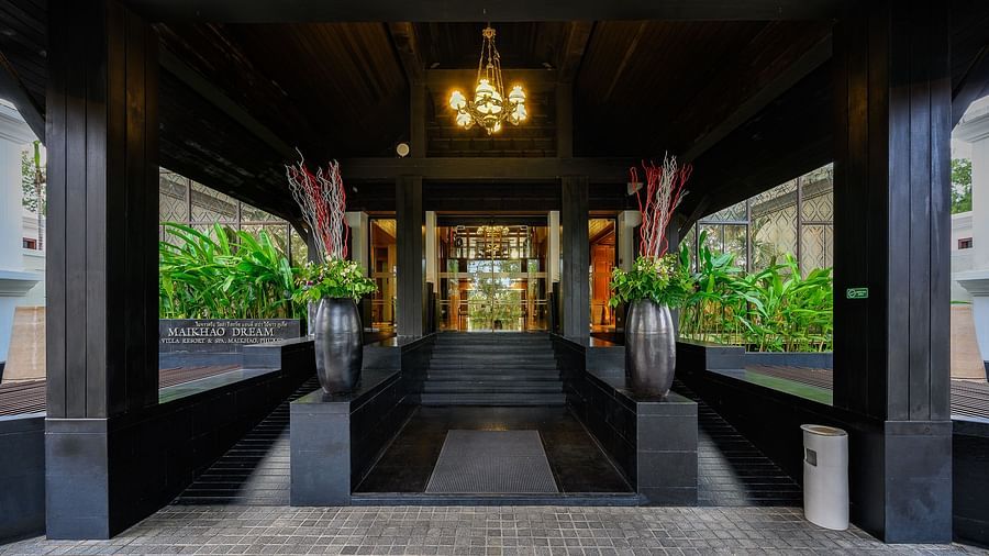 exterior image of the entrance featuring a glass door leading towards the lobby - Maikhao Dream Villa Resort & Spa, Phuket