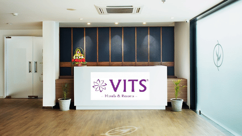 Reception area with a floor to ceiling glass next to it - VITS Select, Rajkot.